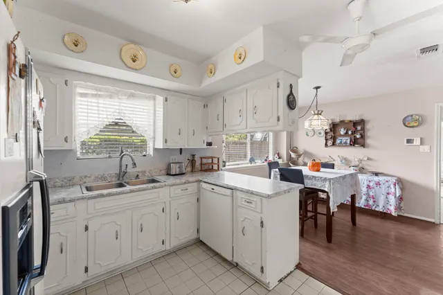 a kitchen with a sink a window and cabinets