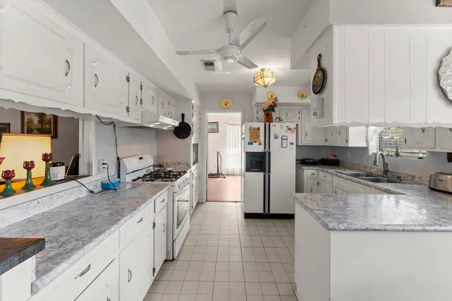a kitchen with stainless steel appliances granite countertop a sink a stove and a refrigerator