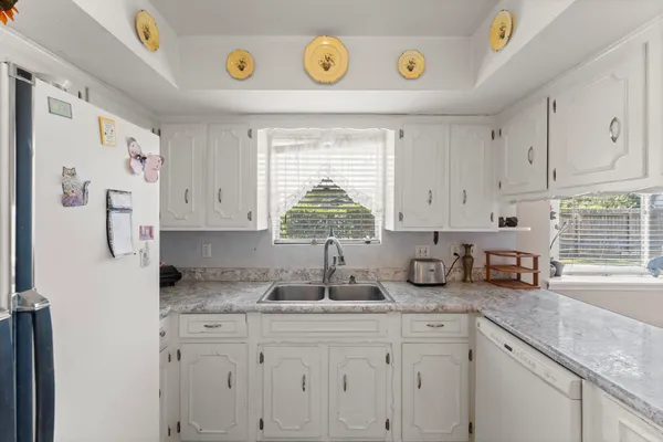 a kitchen with cabinets a window and a refrigerator