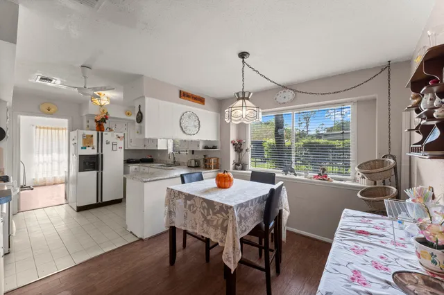 a dining room with furniture a chandelier and wooden floor