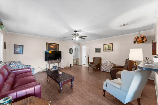 a living room with furniture a flat screen tv and a window