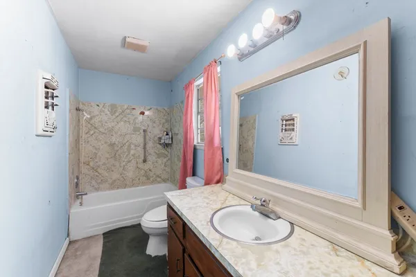 a bathroom with a granite countertop sink toilet and shower