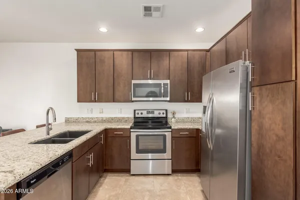 a kitchen with granite countertop stainless steel appliances and wooden cabinets