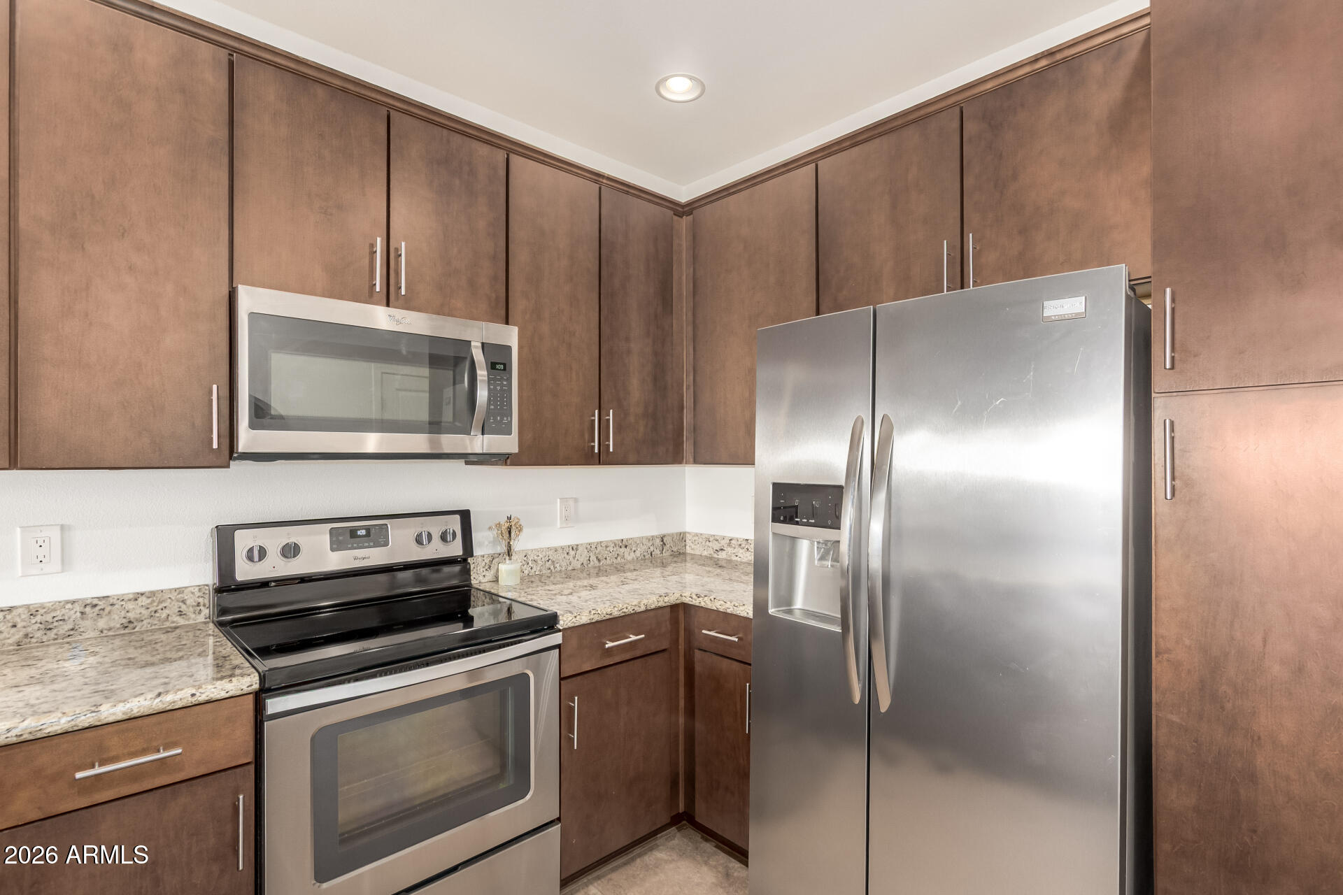 2511 West Queen Creek Road, Unit 239 Chandler, AZ 85248 - Photo 9 of 34 a kitchen with granite countertop stainless steel appliances and wooden cabinets