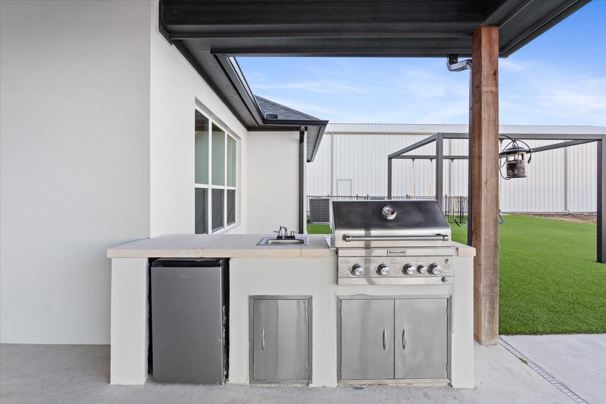 10940 Wedel Cemetery Road Rogers, TX 76569 - Photo 19 of 31 An outdoor kitchen, complete with a built-in grill and sink, offers ideal entertaining.