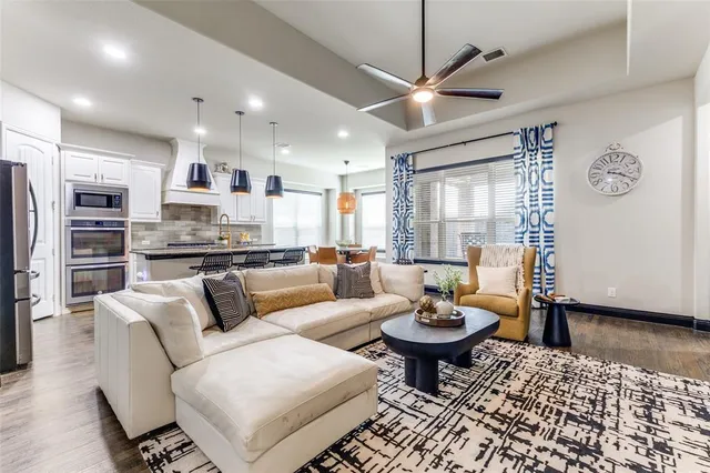 a living room with furniture a table and kitchen view