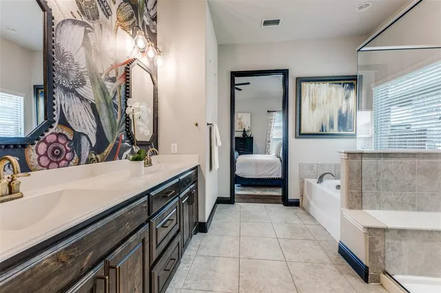 a bathroom with a double vanity sink a mirror and a bathtub