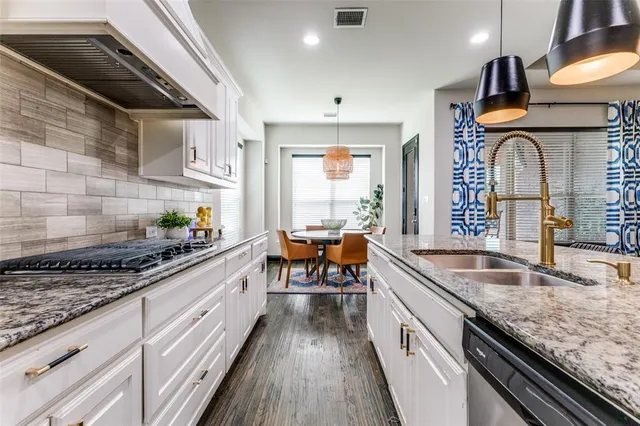 a kitchen with stainless steel appliances granite countertop a sink and wooden cabinets