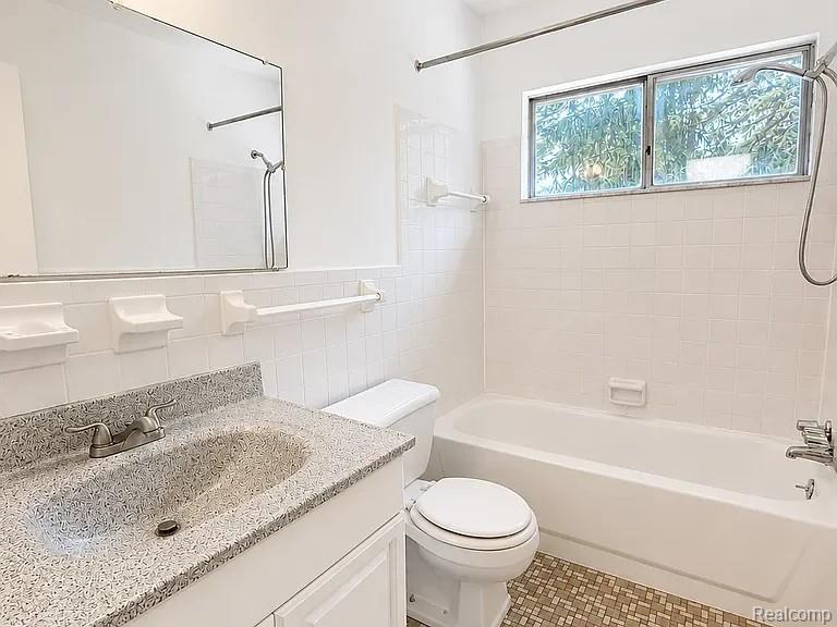 48770 Shelby Road, Unit 13 Utica, MI 48317 - Photo 6 of 10 Bathroom featuring a white vanity with a speckled countertop, integrated sink, and a framed mirror