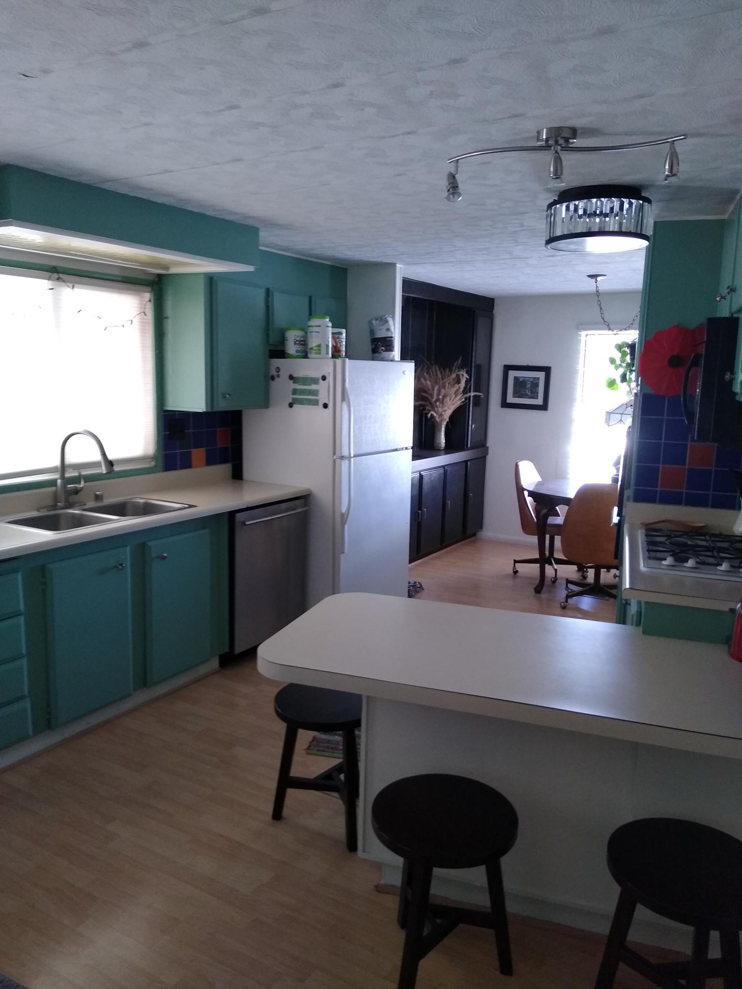 51555 Monroe Street, Unit 26 Indio, CA 92201 - Photo 41 of 54 a kitchen with a table chairs refrigerator and cabinets