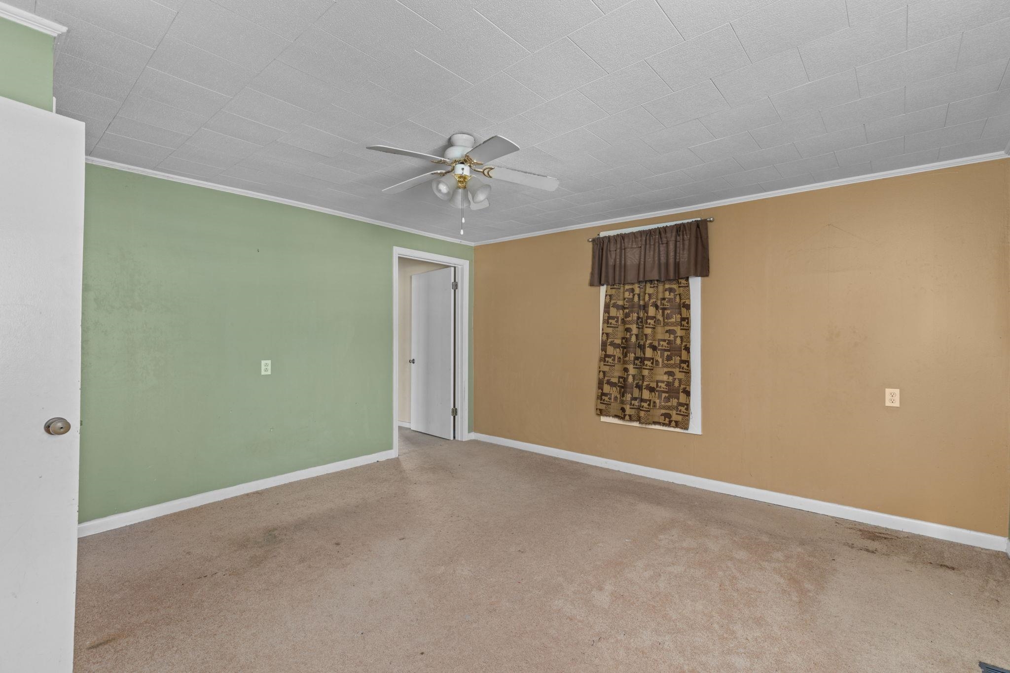 a view of an empty room with a ceiling fan
