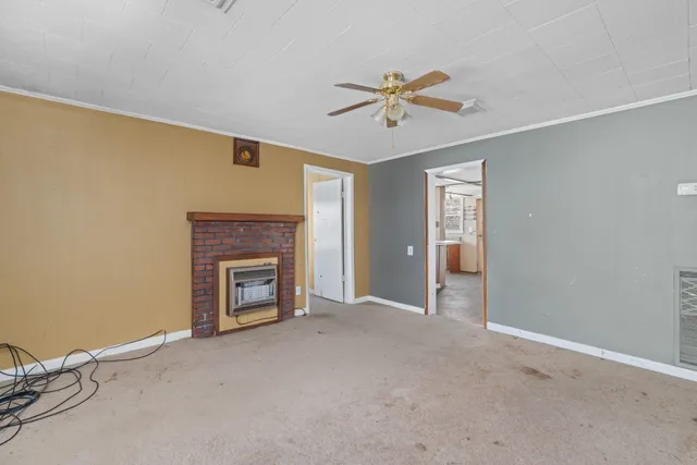 a view of an empty room with a fireplace and a window