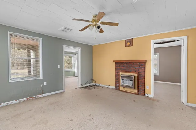 a view of a livingroom with a fireplace and windows