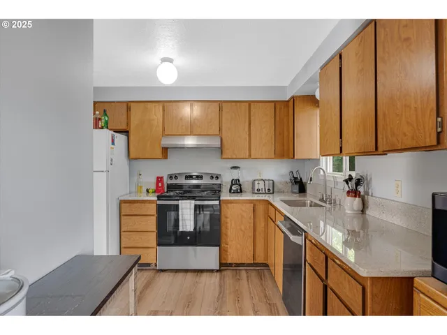 a kitchen with stainless steel appliances granite countertop a sink stove and refrigerator