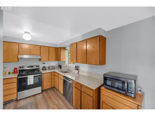 a kitchen with a sink a stove cabinets and a window