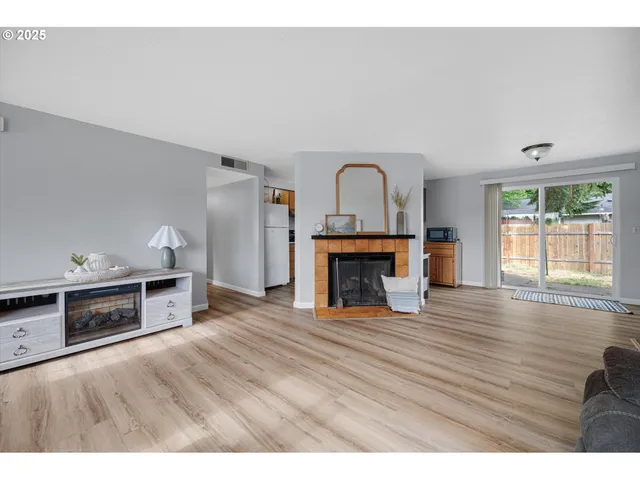 a view of empty room with a fireplace and wooden floor