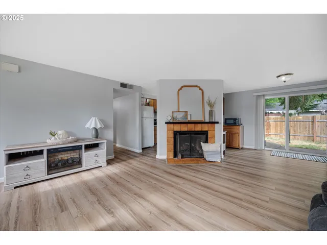 a view of empty room with wooden floor and fireplace