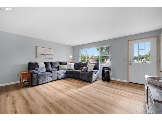 a living room with furniture wooden floor and window