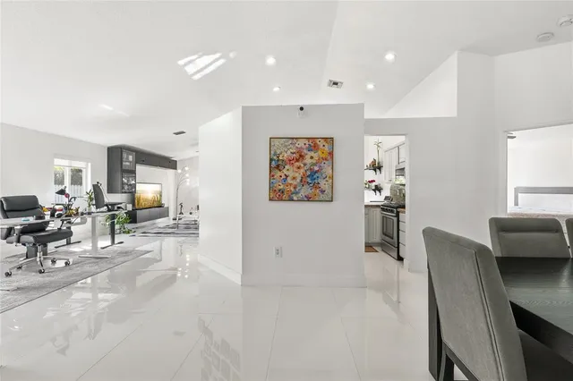 a living room with furniture and a dining table with kitchen view