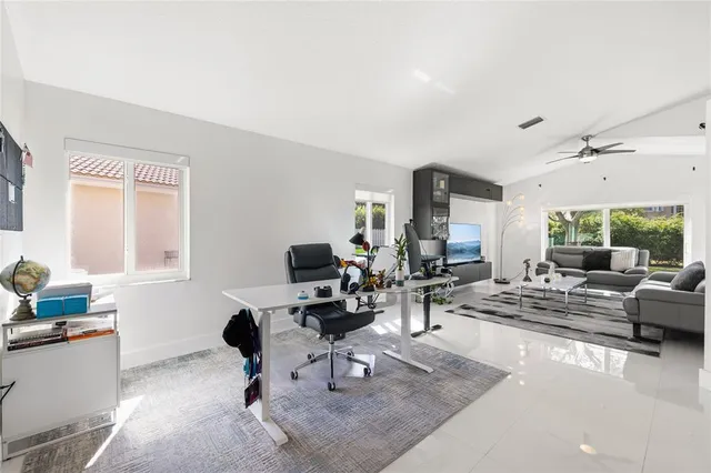 a view of a livingroom with workspace and a window