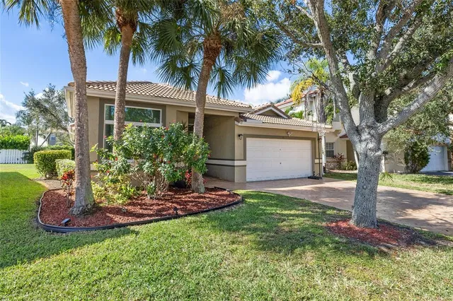 a view of a house with a yard and palm trees