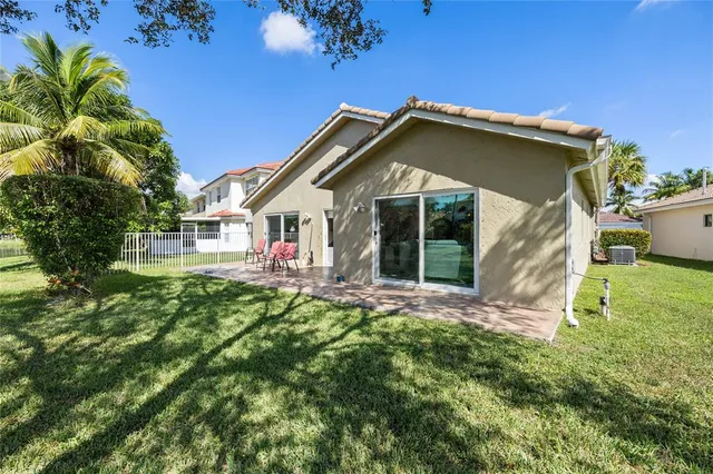 a view of house with yard and outdoor seating