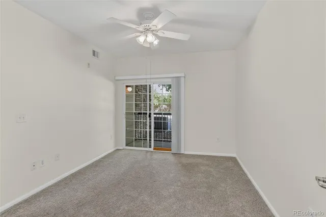 an empty room with chandelier fan