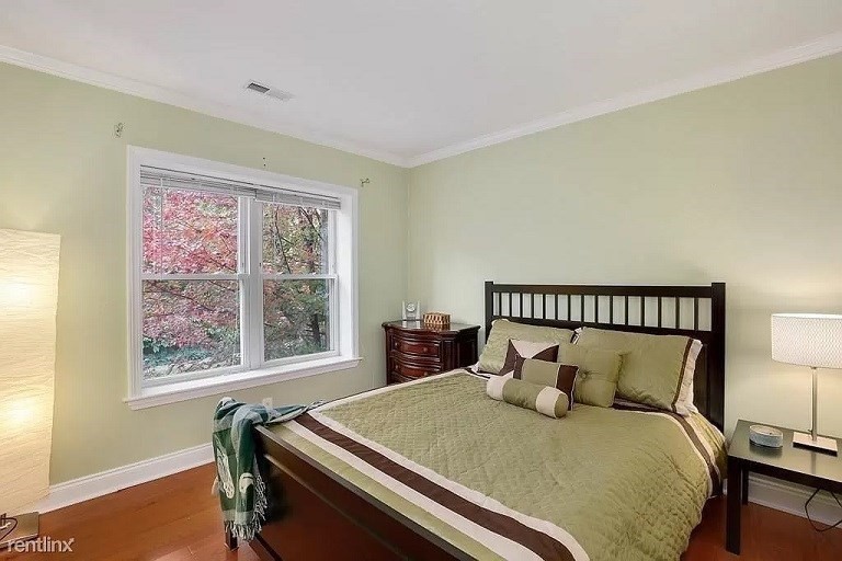 152 Newton Street, Unit 4 Boston, MA 02135 - Photo 7 of 11 a bed sitting in a bedroom next to a window