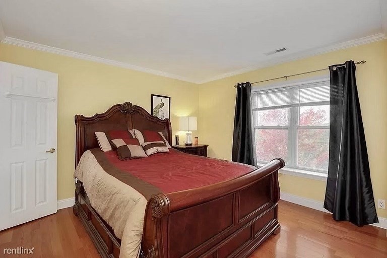 152 Newton Street, Unit 4 Boston, MA 02135 - Photo 8 of 11 a bedroom with a bed and a large window