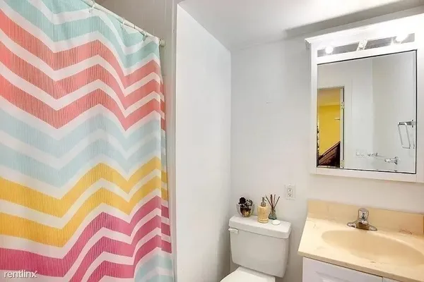 a bathroom with a sink and mirror with toilet