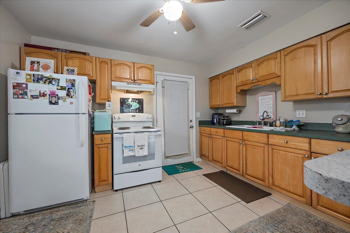 111 A Street St. Augustine Beach, FL 32080 - Photo 5 of 17 a kitchen with granite countertop appliances a sink and cabinets