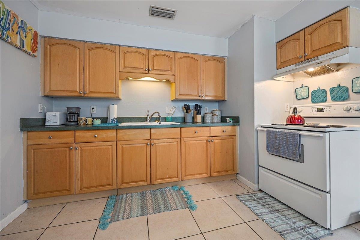 111 A Street St. Augustine Beach, FL 32080 - Photo 10 of 17 a kitchen with cabinets and white appliances