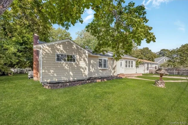 a front view of a house with a garden and trees