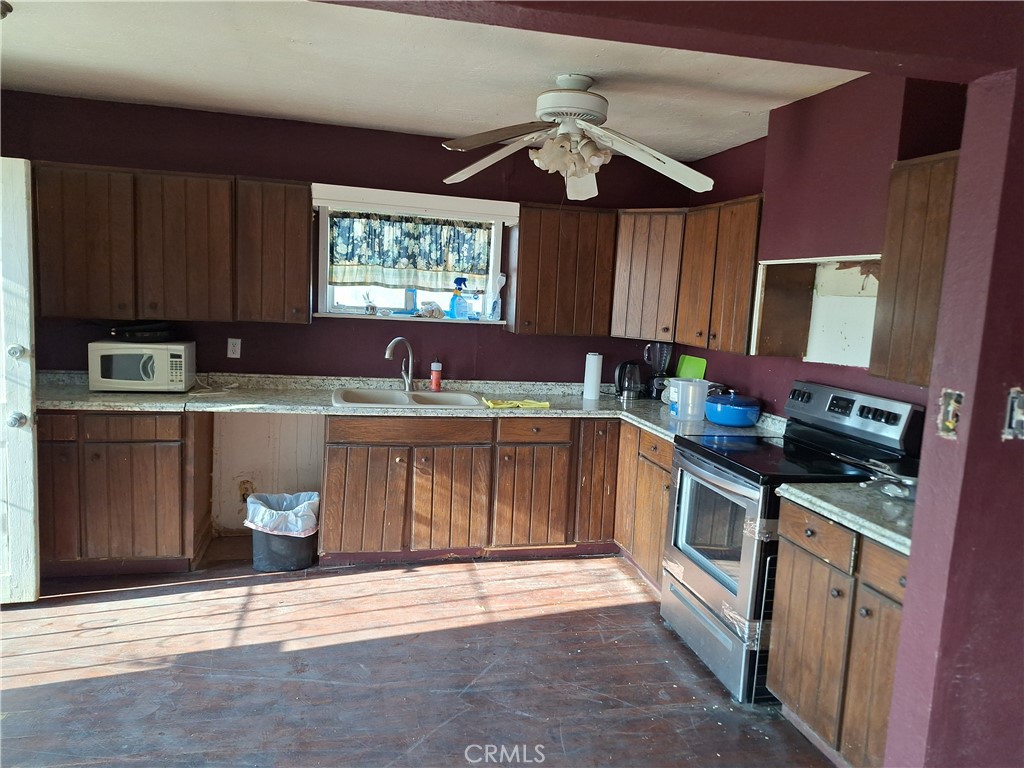 2352 Jacks Ranch Road Ridgecrest, CA 93555 - Photo 15 of 33 a kitchen with stainless steel appliances granite countertop a stove a sink and a microwave