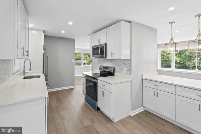 a kitchen with a sink cabinets and wooden floor