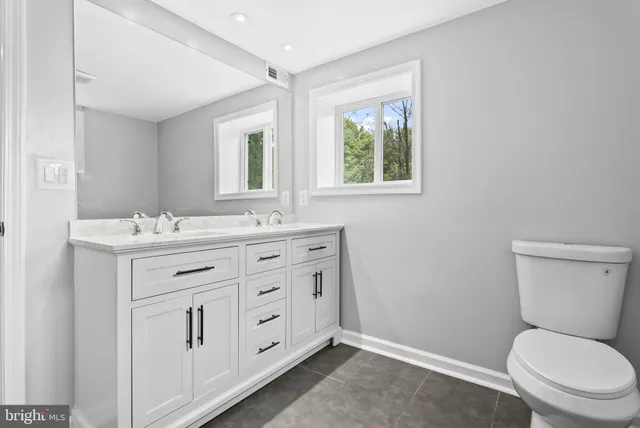 a bathroom with a shower sink vanity and mirror
