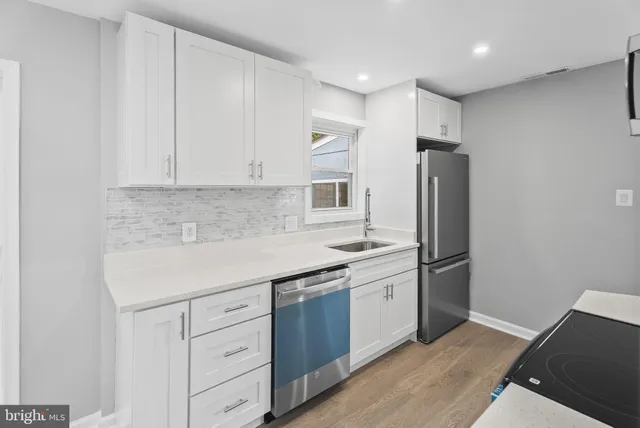 a kitchen with stainless steel appliances a refrigerator sink and cabinets