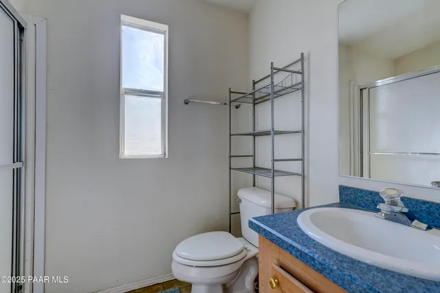 a bathroom with a granite countertop toilet a sink and mirror
