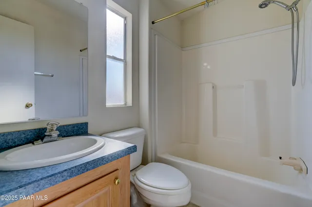 a bathroom with a granite countertop sink toilet a mirror and shower