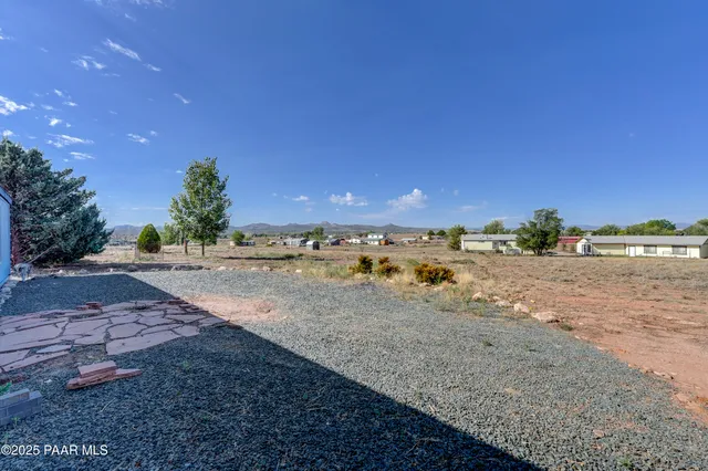 a view of a dry yard with wooden fence