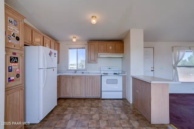 a kitchen with a refrigerator a stove and cabinets