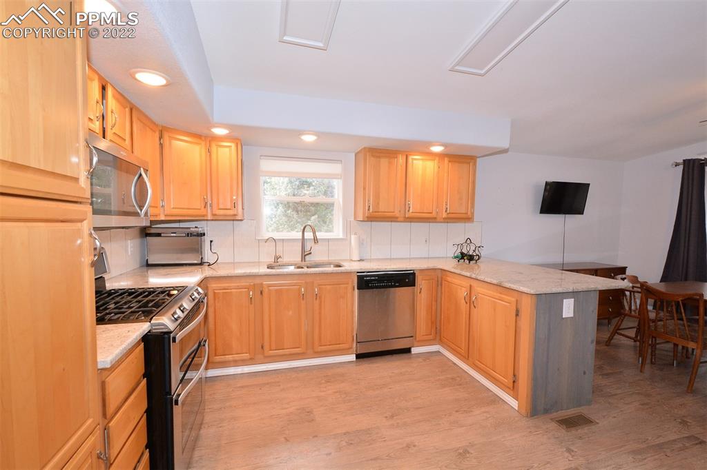 123 Pawutsy Road Florissant, CO 80816 - Photo 11 of 30 a kitchen with stainless steel appliances granite countertop a stove top oven a sink a dining table and chairs