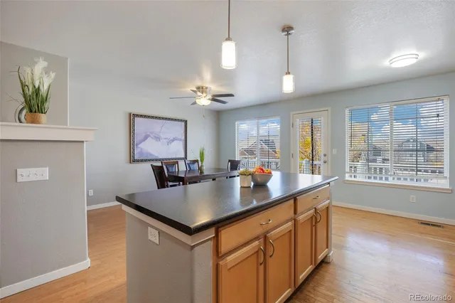a view of kitchen center island wooden floor and living room view