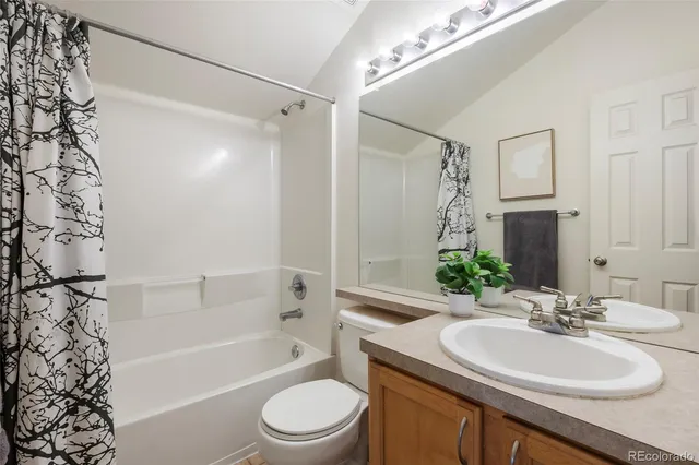 a bathroom with a sink a toilet a tub and shower
