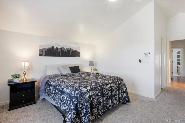 a bedroom with a bed and a lamp on dresser