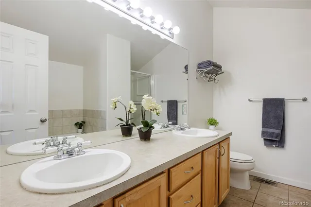 a bathroom with a granite countertop sink a toilet and a mirror