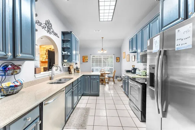 a kitchen with stainless steel appliances granite countertop a sink a stove and a refrigerator