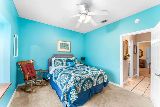 a bedroom with a bed a chair and a chandelier