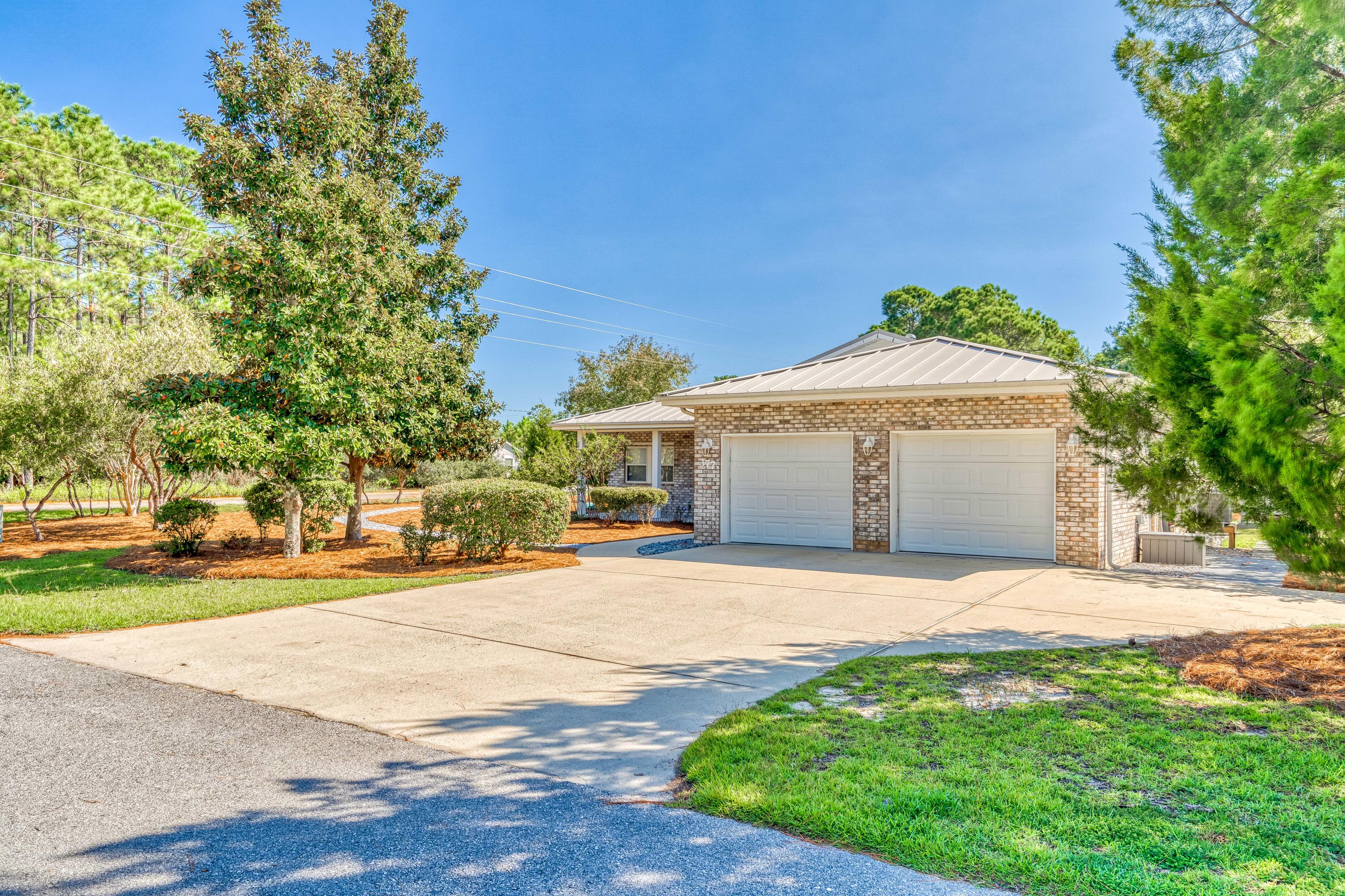 377 Ridge Road Santa Rosa Beach, FL 32459 - Photo 45 of 46 a front view of a house with a yard and garage