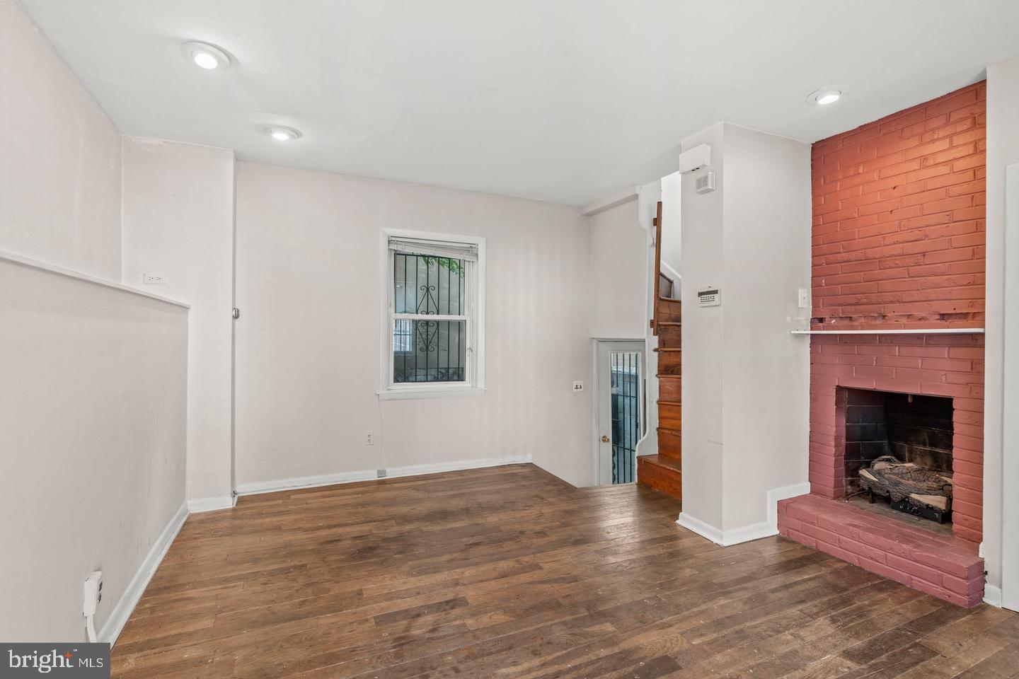 1314 Addison Street Philadelphia, PA 19147 - Photo 2 of 21 a view of an empty room with wooden floor fireplace and a window